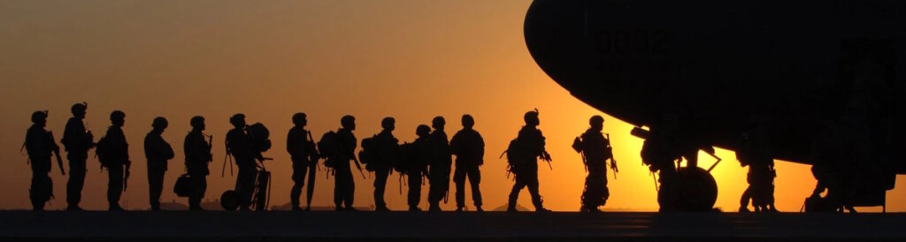 Soldiers bording a plan in sunset